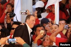 FILE - Jose Antonio Meade, former Mexico Finance Minister, poses for selfies with his supporters in Mexico City, Mexico, Dec. 3, 2017.