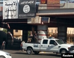 A fighter from the Islamic State, formerly known as the Islamic State of Iraq and the Levant (ISIL), mans an anti-aircraft gun mounted on the rear of a vehicle in Mosul, Iraq, July 16, 2014.