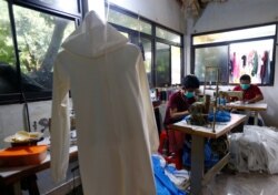 Para penjahit membuat baju pelindung untuk disumbangkan ke rumah sakit di tengah wabah virus corona (COVID-19), di sebuah tukang jahit, di Jakarta, 29 Maret 2020. (Foto: Reuters)