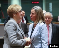 Italy's Defense Minister Roberta Pinotti (L) talks with European Union foreign policy chief Federica Mogherini during a European Union foreign and defense ministers meeting in Brussels, March 6, 2018.