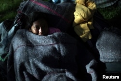 Un migrante, parte de una caravana de miles de personas que viajan desde América Central hacia Estados Unidos, descansa en un campamento improvisado en la Ciudad de México, México, el 6 de noviembre de 2018. REUTERS / Hannah McKay.
