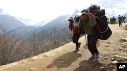 FILE - Nepalese porters carry heavy loads for climbers on their way to Everest Base Camp at Kyangjuma, Nepal in this April 7, 2015, photo.