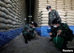 FILE - Soldiers check rice stocks at a warehouse in Ayutthaya province, north of Bangkok, Thailand, July 3, 2014.
