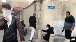 In this photo taken by an individual not employed by the Associated Press and obtained by the AP outside of Iran, people are affected by tear gas fired by anti-riot police to disperse demonstrators in a protest over the country's weak economy, in Tehran, Iran, Dec. 30, 2017.