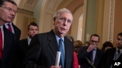 Senate Majority Leader Mitch McConnell, R-Ky., joined at left by Sen. John Barrasso, R-Wyo., and Sen. Todd Young, R-Ind., speaks to reporters asking about the threat of another government shutdown following a strategy meeting in Washington, Jan. 29, 2019