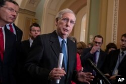 Senate Majority Leader Mitch McConnell, R-Ky., joined at left by Sen. John Barrasso, R-Wyo., and Sen. Todd Young, R-Ind., speaks to reporters asking about the threat of another government shutdown following a strategy meeting in Washington, Jan. 29, 2019.