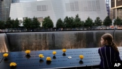 FILE - A girl is seen at the National September 11 Memorial and Museum in New York City, Sept. 8, 2013.