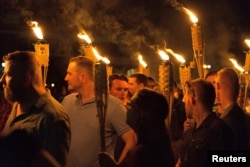 White supremacists carry torches on the grounds of the University of Virginia, on the eve of the "Unite the Right" rally in Charlottesville, Va., Aug. 11, 2017.