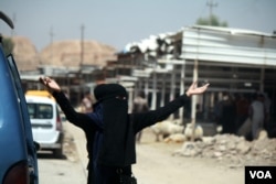 Women still wear burqas in Mosul, but soldiers say those who keep them on now only rarely complain if asked to remove them. Mosul, Iraq, June 8, 2017. (H. Murdock/VOA)