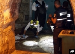 Israeli forensics experts inspect the scene of an attack in Jerusalem's Old City, Oct. 3, 2015.