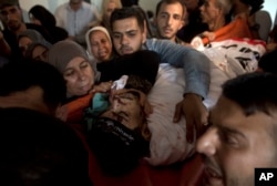 Relatives of Palestinian Naji Zaanin, 25, who was killed in an Israeli airstrike, mourn over his body in the family home during his funeral in town of Beit Hanoun, northern Gaza Strip, Wednesday, Oct. 17, 2018.