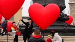 FILE - Families with young children pose for photos in Beijing, Feb. 13, 2021.Struggling with an aging population and declining birth rates, China is trying to shift its population policies to avert a demographic crisis.