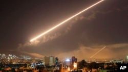 Damascus skies erupt with surface to air missile fire as the U.S. launches an attack on Syria targeting different parts of the Syrian capital Damascus, Syria, early Saturday, April 14, 2018.