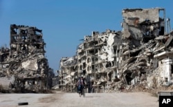 A Syrian boy rides a bicycle through a devastated part of the old city of Homs, Syria, Feb. 26, 2016.