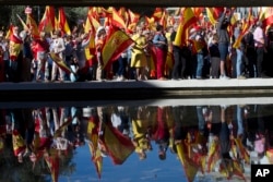 Spaniards pack Colon Square in Madrid, Spain, Saturday, Oct. 7, 2017. Thousands of pro-Spanish unity supporters donning Spanish flags have rallied in a central Madrid plaza to protest the Catalan regional government's drive to separate from Spain.