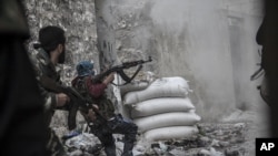 A rebel fighter retreats for cover as enemy fire targets the rebel position during clashes at the Moaskar front line, one of the battlefields in the Karmal Jabl neighborhood, of Aleppo, Syria, October 24, 2012.