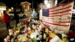 FILE - A U.S. flag displays the name of 26 victims killed Dec. 14, 2012, when Adam Lanza opened fired at Sandy Hook Elementary School in Newtown, Conn.