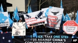 FILE - Uighurs and their supporters rally across the street from the United Nations headquarters in New York, March 15, 2018.