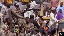 Sojojin Najeriya akan wata motar yaki a lokacin da suke zagaye a wata karamar kasuwa a birnin Maiduguri.