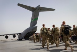 FILE - U.S. soldiers load onto a U.S. military plane as they leave Afghanistan, at the U.S. base in Bagram, north of Kabul, Afghanistan, July 14, 2011.