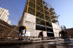 FILE - Laborers work at the construction site of a building in Tehran, Iran, Jan. 20, 2016.