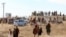 FILE - Afghan men leave after watching the public execution of a man by the Taliban at a football stadium in Gardez, in Paktia province, on Nov. 13, 2024. Taliban authorities defend their practice of public executions and public floggings, despite global outcry. 