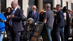 President Joe Biden helps a voter in a wheelchair in line at a polling station before casting his early-voting ballot for the 2024 general elections, New Castle, Delaware, Oct. 28, 2024.