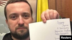 Kyrylo Tymoshenko sostiene una nota mientras presenta su renuncia, pidiéndole al presidente Volodymyr Zelenskyy que lo releve de sus funciones, en esta imagen tomada en un lugar desconocido y publicada en las redes sociales el 24 de enero de 2023. 