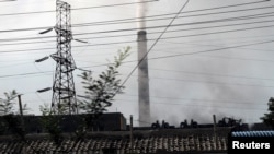 FILE - Smoke rises from a chimney in downtown Pyongyang, North Korea Sept. 11, 2018.