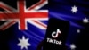 Logo aplikasi video TikTok milik China terlihat di smartphone di depan gambar bendera nasional Australia, 4 April 2023. Australia pmengatakan akan melarang TikTok di perangkat milik pemerintah. (Foto: REUTERS/Tingshu Wang)