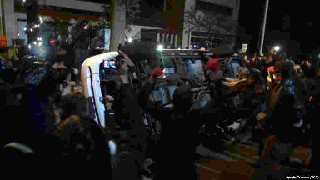Au cours d&#39;une deuxième nuit de violences à la suite de la décision d&#39;un grand jury de ne pas inculper un policier blanc dans la mort par balle d&#39;un adolescent noir, les manifestants attaquent et renversent une voiture de police à l&#39;extérieur Ferguson City Hall, à Ferguson, Missouri, le 25 novembre 2014 .
