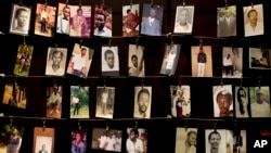 FILE - Family photographs of some of those who died hang in a display in the Kigali Genocide Memorial Centre in Kigali, Rwanda, April 2014. Officials said Rwandan Ladislas Ntaganzwa was arrested by Interpol agents in Congo, Dec. 7, 2015.