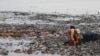 FILE - A worker collects garbage, most of which is plastic and domestic waste, along the shore of Jakarta, Indonesia, June 8, 2023. 