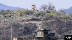 FILE - A file picture taken on April 15, 2022, from the South Korean border city of Paju shows soldiers, top outside a guard post in North Korea, as seen beyond a South Korean guard post, bottom.