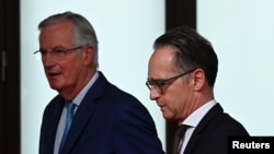 Menteri Luar Negeri Jerman Heiko Maas dan negosiator Brexit Uni Eropa Michel Barnier meninggalkan ruangan, seusai memberikan keterangan kepada media di Berlin, Jerman, 5 Oktober 2020. (Tobias Schwarz / Pool via Reuters)