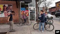 High school students hang out on a Brooklyn street corner, Friday, March 20, 2020 in New York. The city's public schools are closed due to the coronavirus. (AP Photo/Mark Lennihan)