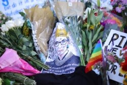 Flowers and tributes are seen as people gather in front of the U.S. Supreme Court following the death of U.S. Supreme Court Justice Ruth Bader Ginsburg, in Washington, Sept. 19, 2020.