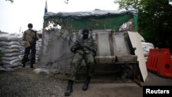 Pro-Russian fighters man a checkpoint in the eastern Ukrainian city of Donetsk, July 7, 2014.