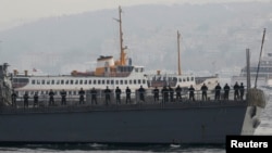 FILE - U.S. sailors stand aboard the USS Ross as it leaves from the port of Istanbul, Nov. 13, 2014.