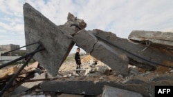 Дете поминува покрај уништената куќа во Рафа на 18 февруари 2024 година, по израелските воздушни напади во текот на ноќта врз јужниот пограничен град на појасот Газа. во услови на тековни битки меѓу Израел и Хамас