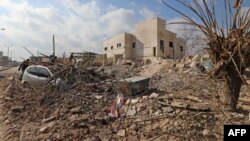 FILE - Destruction is seen around the Udai hospital following airstrikes on the town of Saraqeb in Syria's northwestern province of Idlib, Jan. 29, 2018. Syrian troops had been advancing on Idlib as part of a fierce offensive launched in late December with Russian backing.