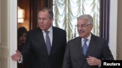Russian Foreign Minister Sergei Lavrov, left, shows the way to his Pakistani counterpart Khawaja Asif during a meeting in Moscow, Feb. 20, 2018. 