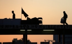 Protesters walk on top of a bridge near Hong Kong Baptist University, in Hong Kong, Nov. 16, 2019. Most anti-government demonstrators abandoned their positions Saturday.