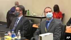 Defense attorney Eric Nelson, left, and former Minneapolis police officer Derek Chauvin listen as Hennepin County Judge Peter Cahill presides over pre-trial motions prior to opening statements, March 29, 2021.