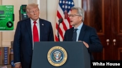 资料照片：英伟达CEO黄仁勋在白宫举行的“投资美国”活动上发表讲话，美国总统唐纳德·特朗普在旁聆听。(2025年4月30日)