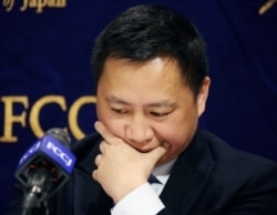 FILE - Veteran Chinese dissident Wang Dan pauses during a press conference in Tokyo, Japan, May 29, 2019.