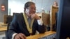 FILE - Cambodian Information Minister Khieu Kanharith looks at a monitor during the Inauguration of Radio France Internationale in Phnom Penh, June 20, 2013. 