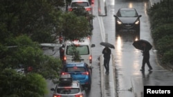 Pedestrians brave strong wind and rain in Sydney, New South Wales, Australia, Feb. 9, 2020. 