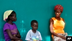 FILE - People suspected of having Ebola await treatment outside a hospital near Monrovia, Liberia, on Oct. 24, 2014. More than 10,000 people have been infected with the virus, the World Health Organization reported. 