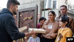 A volunteer delivers Christmas presents to residents of Iraq's northern Christian town of Qaraqosh on Christmas Eve, Dec. 24, 2020.
